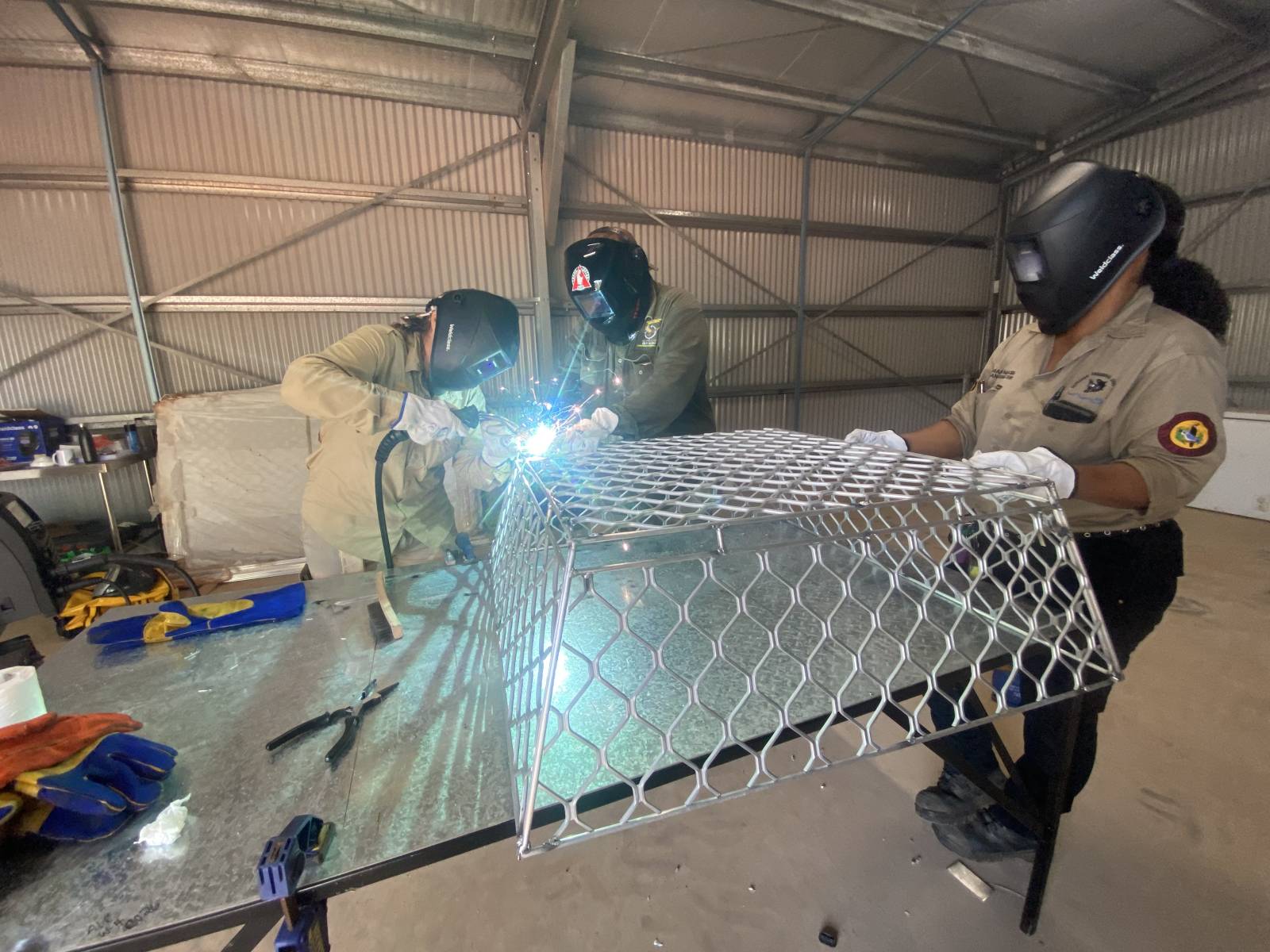 Students learning how to weld to make protective cages for turtles